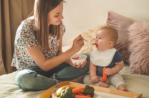 Baby Led Weaning Grundlagen Kind wird gefuettert